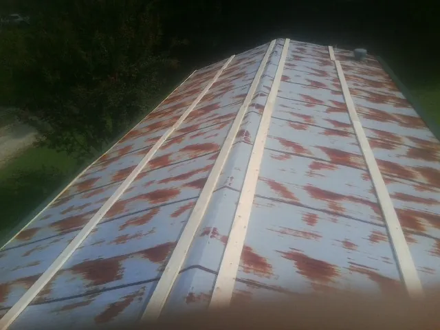 Rusted metal roof panels with new wood purlins before replacement — Storm Damage Roof Repair in Scottsboro by Roofing Brothers