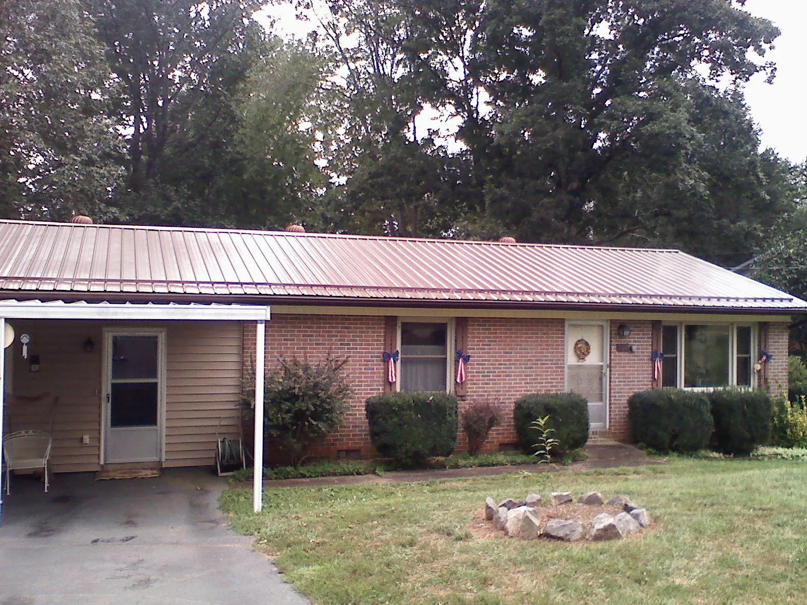 Bronze metal roof and carport on a brick ranch home — Roof Repair work by our crew in Scottsboro
