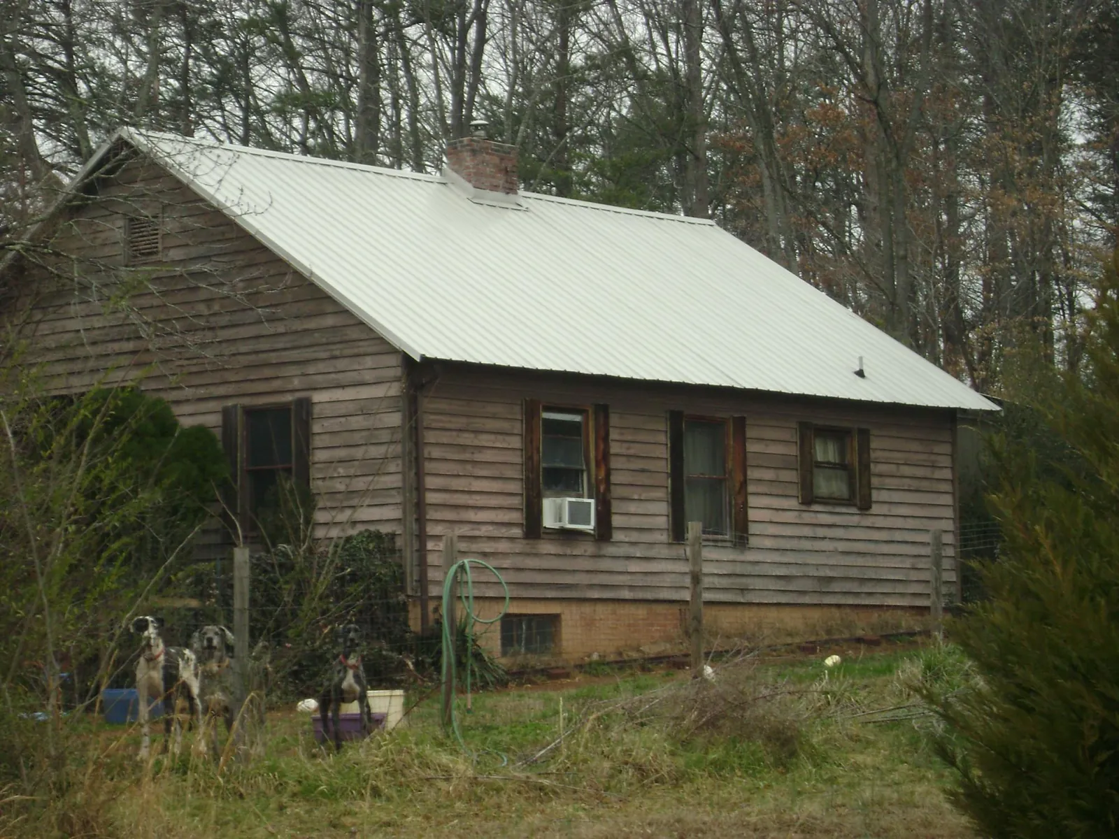 White metal roof on an old wood sided farmhouse, from a Metal Roof Installation job in Scottsboro